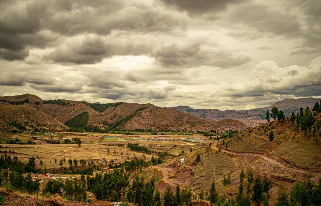 árvores e montanhas ao longe com céu nublado em cusco, peru