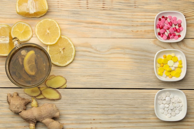 Arzneimittel Tabletten Hustensirup Thermometer und Volksheilmittel zur Behandlung von Influenza und Erkältung auf einem natürlichen Holztisch