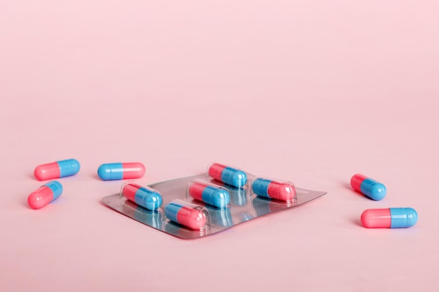 Arzneimittelpillen auf hellem Hintergrund Arzneimittel und verschreibungspflichtige Pillen liegen flach im Hintergrund Blaue und rosa medizinische Tabletten im Blister