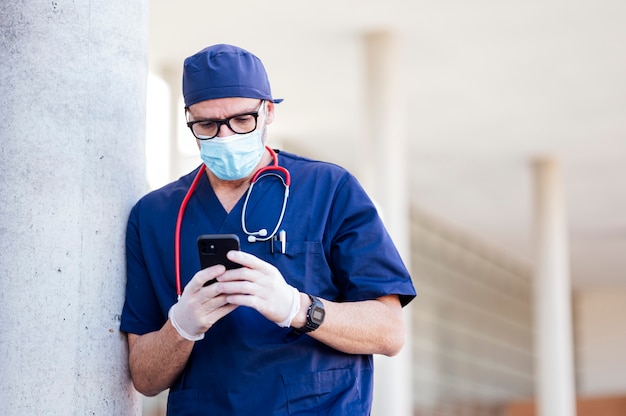 Arzt außerhalb des Krankenhauses mit Smartphone