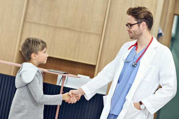 Arzt begrüßt Jungen in der Klinik