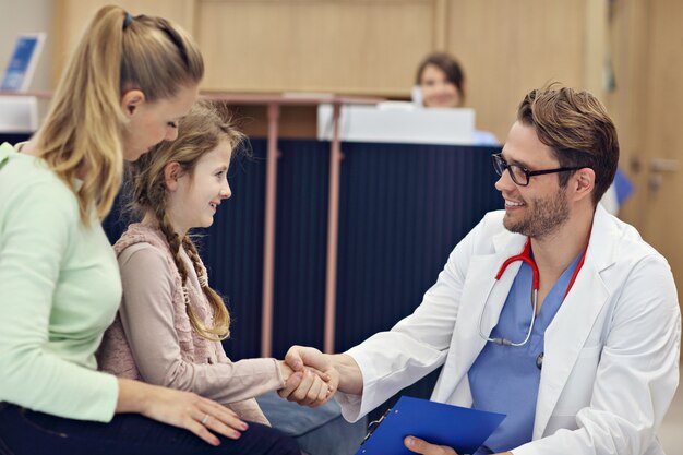 Arzt begrüßt Mutter und Tochter in der Klinik