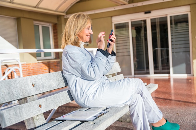 Foto arzt benutzt sein handy während einer arbeitspause außerhalb des krankenhauses