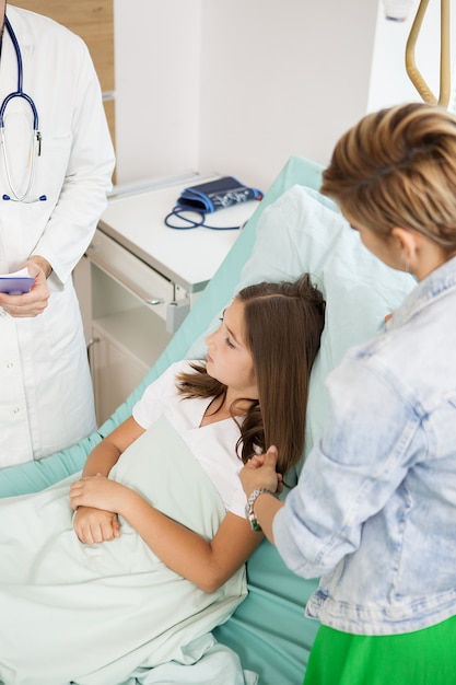 Arzt besucht geduldiges Mädchen im Krankenzimmer