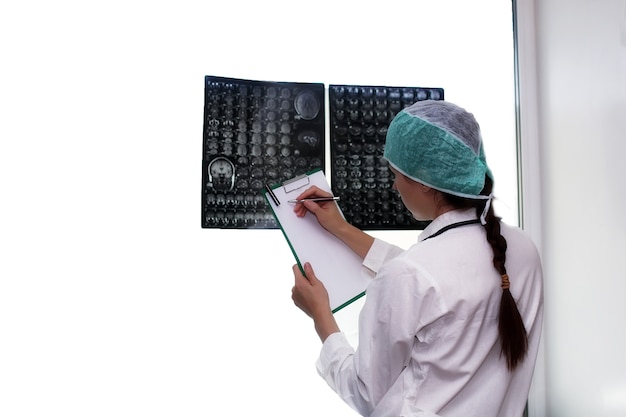 Arzt, der ein Bild eines MRT-Arbeitsablaufs des Gehirns in einem diagnostischen Krankenhaus hält