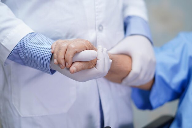 Arzt, der sich die Hände berührt, asiatische ältere oder ältere alte Dame, Patientin, die mit Liebe betreut wird, hilft, zu ermutigen und Mitgefühl auf der Krankenhausstation zu entwickeln, gesundes, starkes medizinisches Konzept