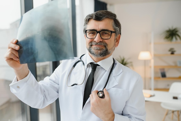 Arzt eines älteren Mannes untersucht Röntgenbild der Lunge in einer Klinik