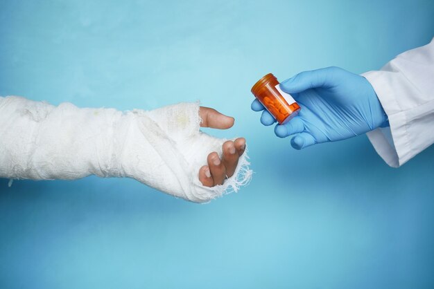Arzt empfiehlt Medizin für verletzte schmerzende Hand mit Verband