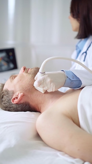 Arzt führt eine Ultraschalluntersuchung des Halses bei einem männlichen Patienten durch