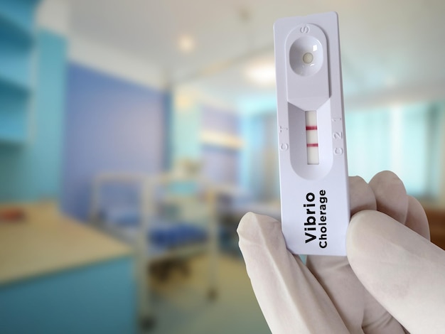 Arzt halten Vibrio cholerae Test positives Testergebnis Schnelltestkassette.