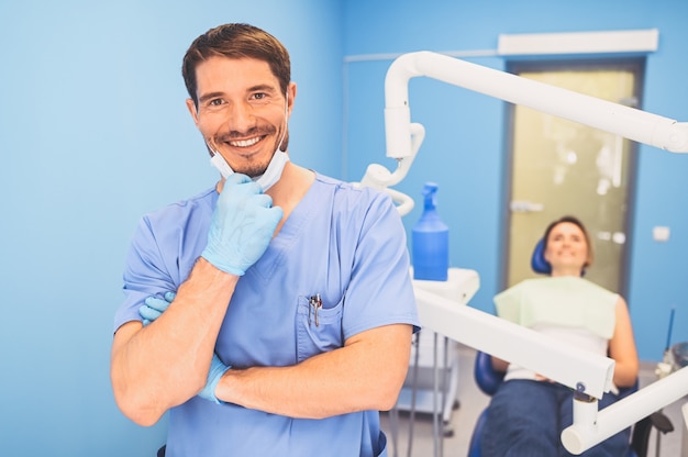 Arzt in blauer medizinischer Uniform in der Zahnarztpraxis und Patient auf dem Zahnarztstuhl