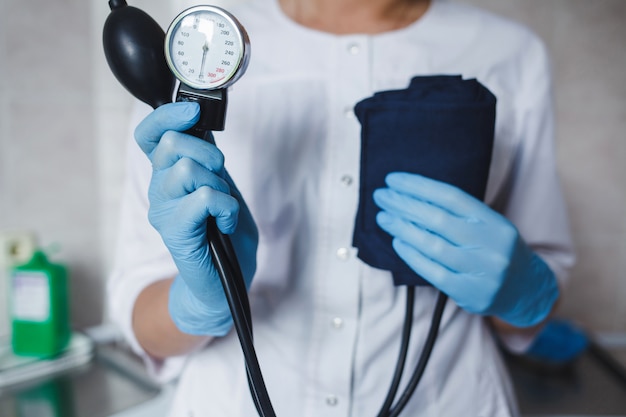 Arzt in Handschuhen mit Blutdruck