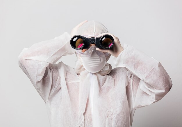 Arzt in Schutzanzug und Brille, Maske mit Fernglas