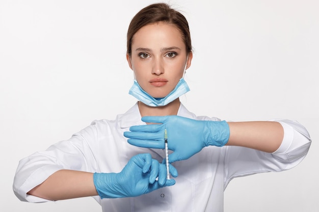 Arzt in Uniform und Handschuhen mit Spritze