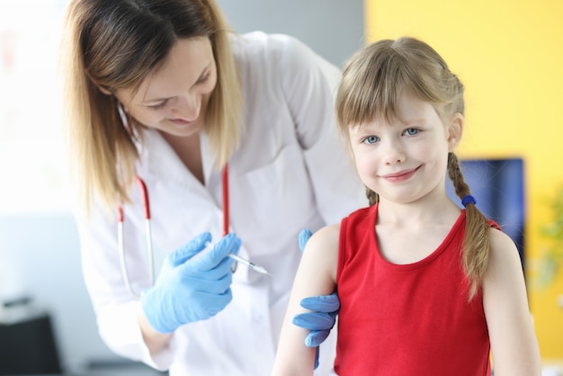 Arzt injiziert kleines Mädchen in Schulterimpfung Entwicklung der Immunität im Kinderkonzept