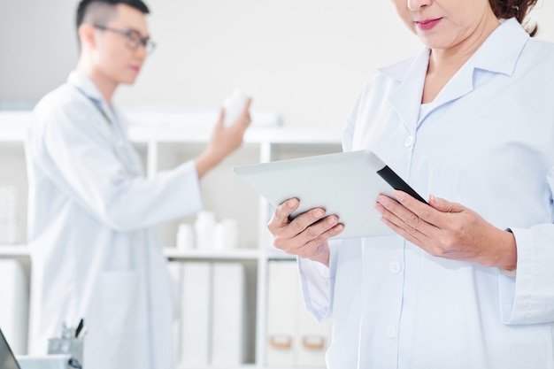 Arzt liest Daten auf dem Tablet-Bildschirm