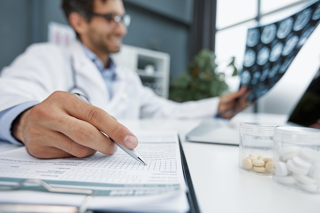 Arzt macht Notizen oder Rezepte mit Bleistift, Stift und Papier für die Krankenschwester aus nächster Nähe