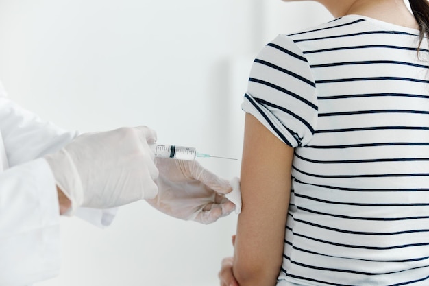 Arzt mit medizinischen Handschuhen injiziert den Impfstoff in die Hand des Patienten, Nahaufnahme. Hochwertiges Foto