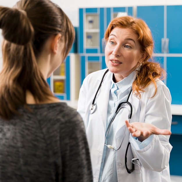 Foto arzt mit patient erklärt die symptome