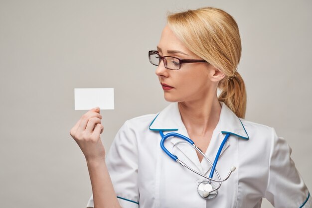 Arzt oder Krankenschwester des medizinischen Arbeiters, der leere Visitenkarte zeigt