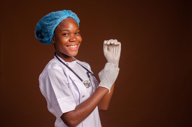 Arzt oder Krankenschwester, die chirurgische Handschuhe mit persönlicher Schutzausrüstung anpasst