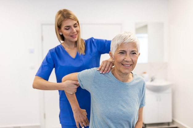 Arzt oder Physiotherapeut untersucht die Behandlung des verletzten Arms eines älteren Patienten, indem er sich in der Klinik dehnt und Schmerzen bei der Rehabilitationstherapie durchführt