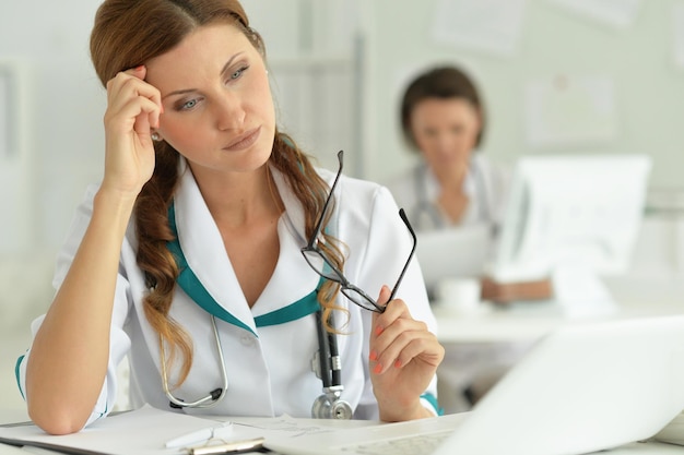 Arzt sitzt am Schreibtisch bei der Arbeit im Krankenhaus