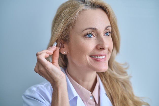 Arzt testet Hörgerät in seinem Ohr