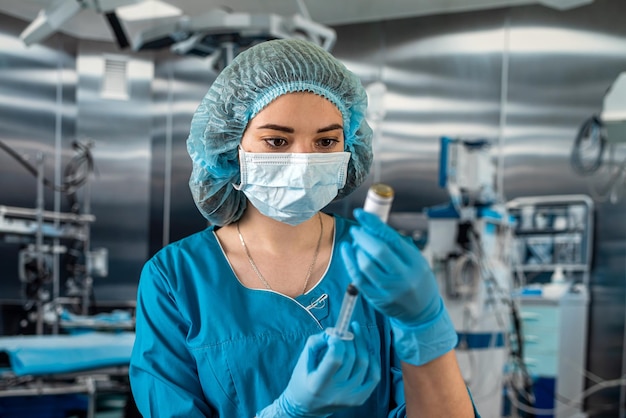 Arzt trägt blaue Uniform mit Handschuh voller Virenschutz und hält Spritze mit Medizin