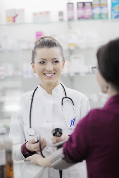 Arzt überprüft Blutdruck und Herzfrequenz in einem Krankenhaus oder in einer Apotheke bei einer jungen weiblichen Patientin