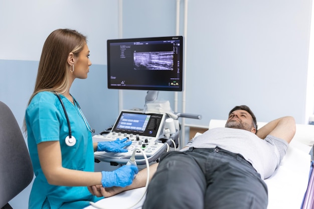 Arzt überprüft Ultraschall des Patientenarms in einer Klinik für medizinische und gesundheitliche Forschung in einem Krankenhaus Mann berät sich mit Chirurgen Ultraschall der Venen des oberen Xtremities-Konzepts