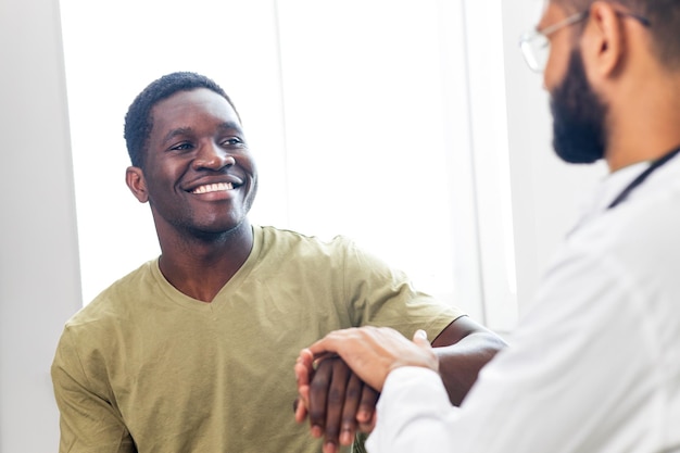 Arzt und männlicher Patient sprechen bei der Büroberatung zur weiteren Behandlung