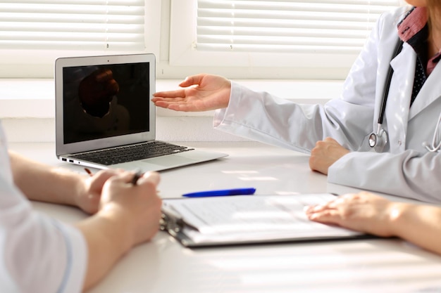 Arzt und Patient besprechen etwas nur Hände am Tisch