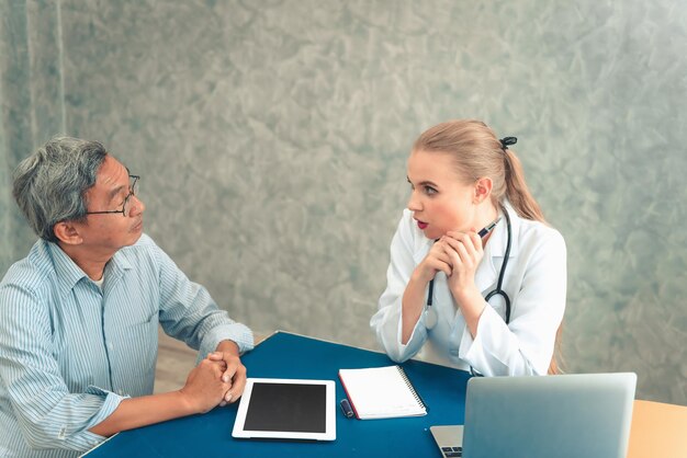 Arzt und Patient diskutieren am Tisch im Büro