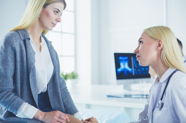 Arzt und Patient diskutieren etwas, während sie am Tisch sitzen Medizin- und Gesundheitskonzept