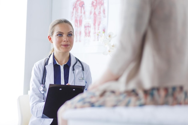 Arzt und Patient diskutieren etwas, während sie am Tisch sitzen Medizin- und Gesundheitskonzept