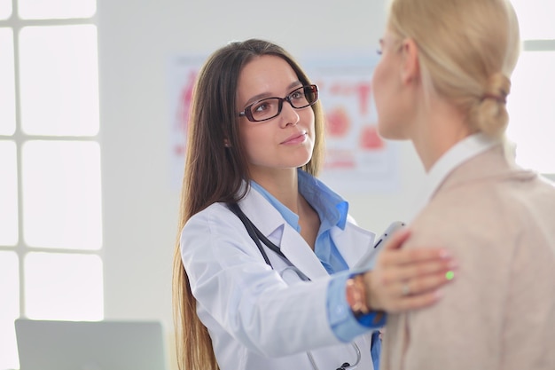 Arzt und Patient diskutieren etwas, während sie am Tisch sitzen Medizin- und Gesundheitskonzept