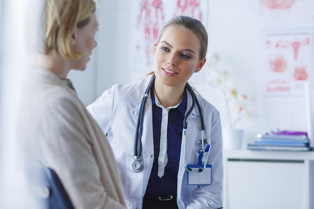 Arzt und Patient diskutieren etwas, während sie am Tisch sitzen Medizin und Gesundheitsversorgung Konzept