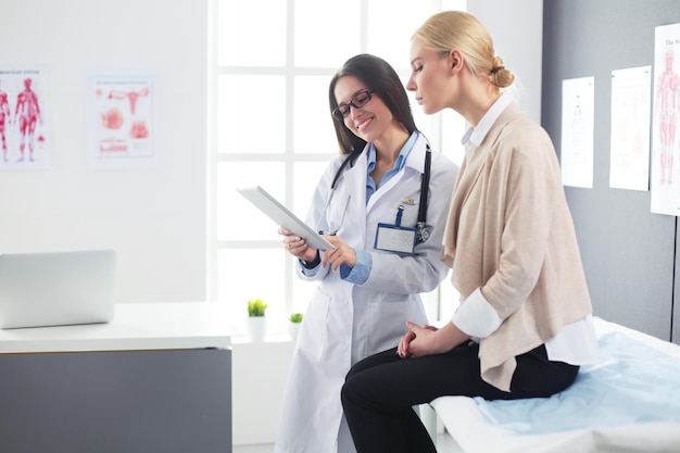 Arzt und Patient diskutieren etwas, während sie am Tisch sitzen Medizin und Gesundheitsversorgung Konzept