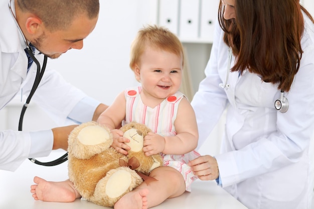 Arzt und Patient Fröhliches süßes Baby bei der Gesundheitsprüfung Medizin- und Gesundheitskonzept