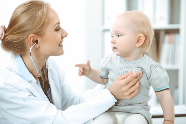 Arzt und Patient im Krankenhaus. Kleines Mädchen wird vom Arzt mit Stethoskop untersucht. Medizin-Konzept.