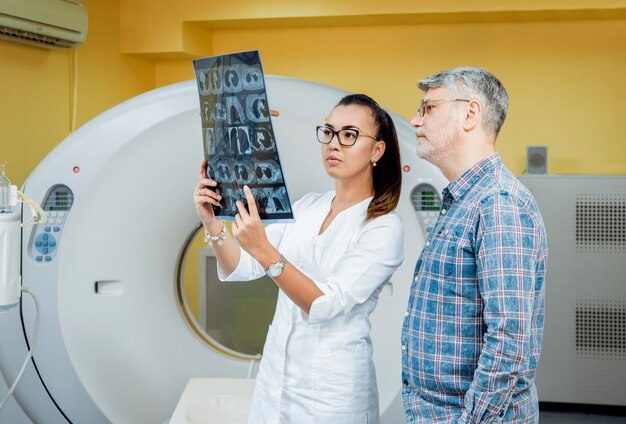 Arzt und Patient im Raum der Computertomographie im Krankenhaus.