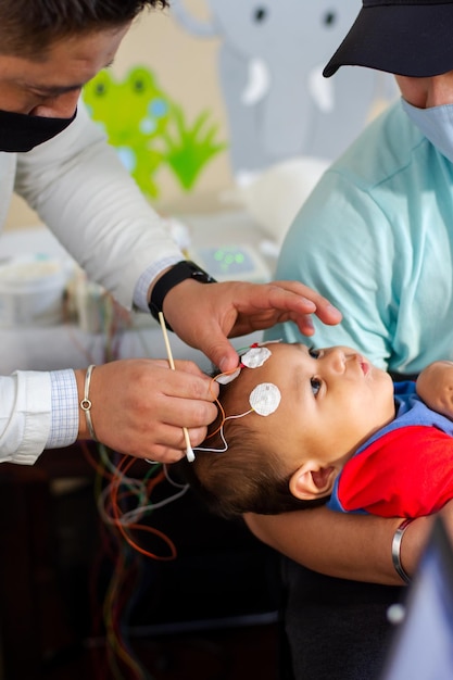 Arzt untersucht die Kopfdrähte des Babys sorgfältig