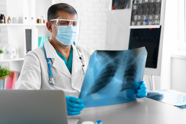 Arzt untersucht Lungenröntgen-Scan in seinem Büro im Krankenhaus Nahaufnahme