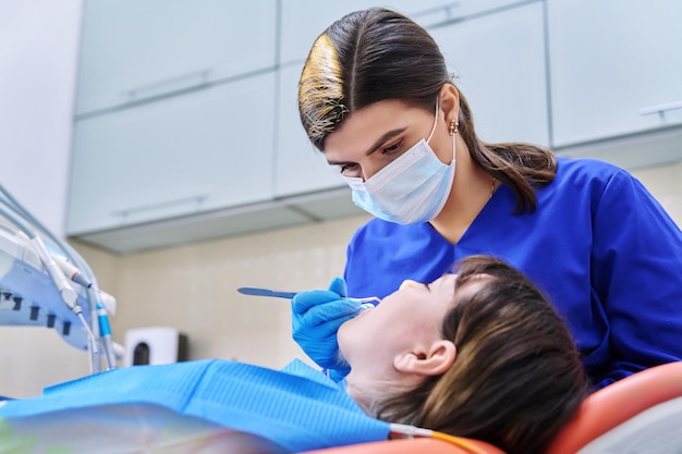 Arzt Zahnarzt behandelt Zähne einer jungen Patientin im Teenageralter