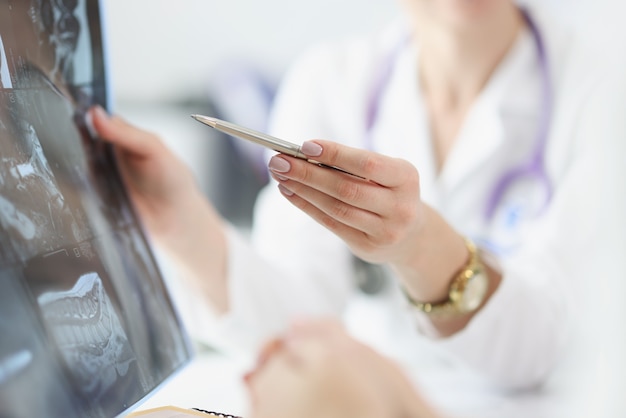 Arzt zeigt dem Patienten ein Röntgenbild mit Magnetresonanztomographie