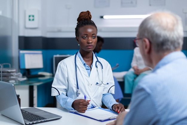 Arztexperte im Gesundheitswesen, der mit älteren Patienten über Gesundheitsgefahren und Behandlungsvorteile spricht. Klinikarzt, der über Kontrolltermine, verschriebene Medikamente und Beratungsresultate spricht