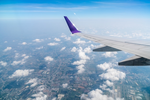 As asas do avião no fundo do céu azul e nuvens bonitas