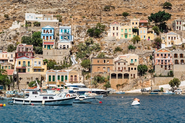 As casas coloridas tradicionais e o porto na Grécia do Dodecaneso da ilha de Symi