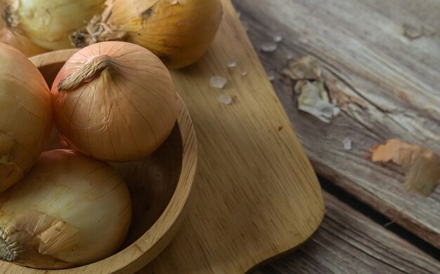 As cebolas na mesa de madeira para alimentos ou conceito de cozinha.